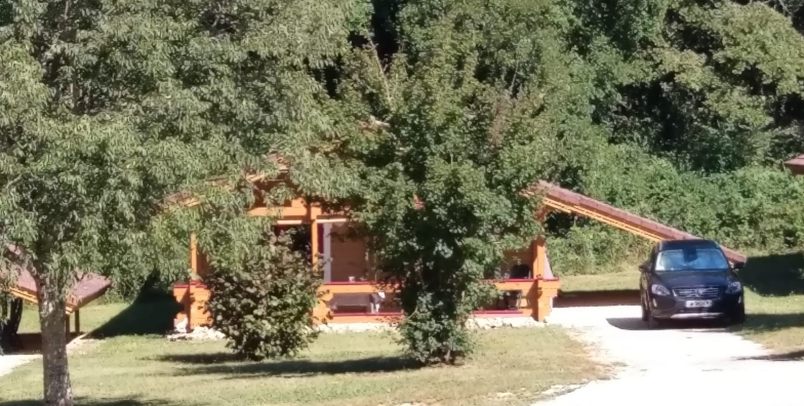Le chalet avec son carport et son jardin ouvert